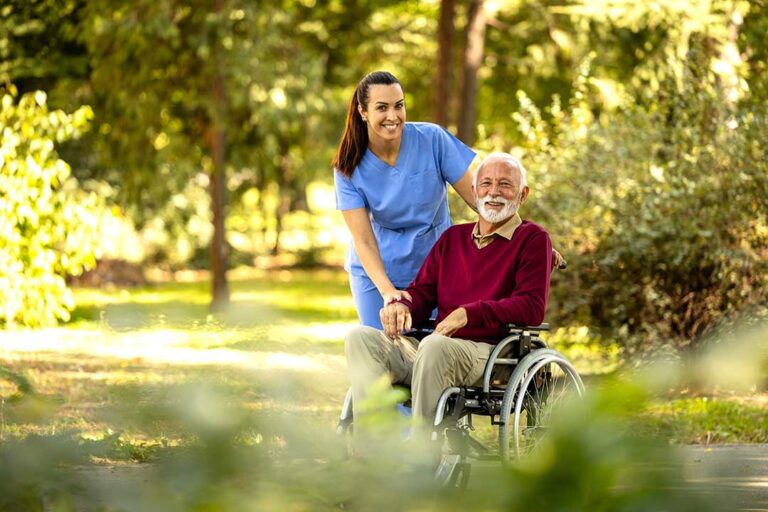 An older adult follows a daily schedule with help from a caregiver in a cozy, well-lit communal living space.